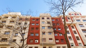 A multi-story building with a consistent architectural style, featuring a central red section and beige sections on either side. - Ibiza - Parque del Retiro- 2 Bedrooms (Madrid)