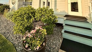 A multi-story building with a balcony on the second floor, a door with a number plaque, and a small garden area with a potted plant. - ⨳ Lake Erie Waterfront condo conveniently located near Jet Express - 1BR 1 BA ⨳ (Port Clinton)