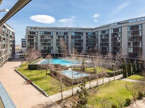 A modern apartment building with a swimming pool surrounded by well-maintained lawns and trees. - Las Tablas - 3 Bedrooms with terrace (Madrid)