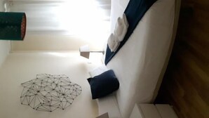 Een moderne kamer met een witte bank, een geometrisch kunstwerk aan de muur en een houten vloer.