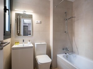 Et moderne badeværelse med toilet, vask og badekar.