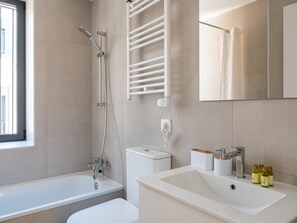 Ein modernes Badezimmer mit Badewanne, Dusche, Toilette und Waschbecken.