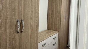 Un armario con puertas de madera y un aparador blanco con cajones.