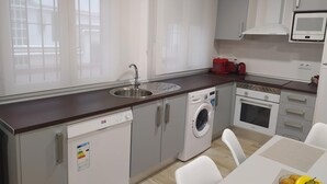 Eine moderne Küche mit Geschirrspüler, Waschmaschine, Backofen und Mikrowelle.