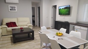 Ein modernes Wohnzimmer mit einer Couch, einem Couchtisch und einem Essbereich mit Stühlen und einem Tisch.