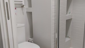 Ein Badezimmer mit Toilette, Waschbecken und einer Duschkabine.
