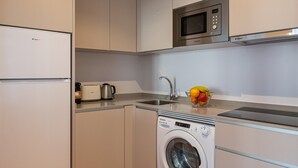 Una cocina compacta con microondas, tostadora y lavadora.