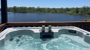 A hot tub with a view of a lake and forest.
