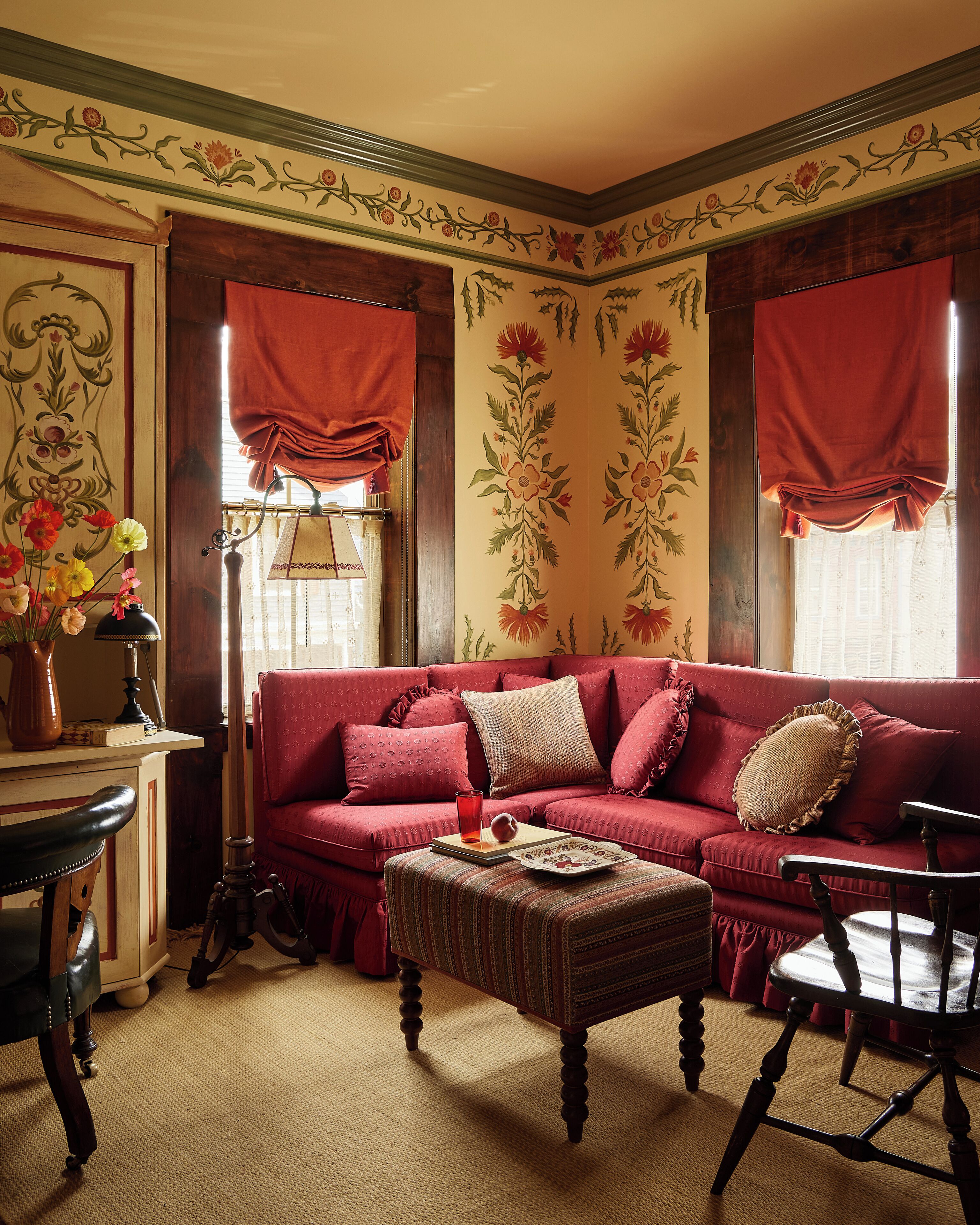 A cozy living room with a red sofa, a wooden coffee table, and a vintage lamp.