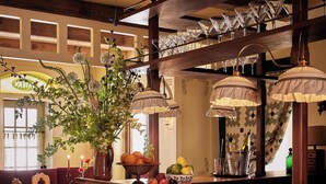 A bar area with wooden stools, a fruit bowl, and a bottle of champagne. - Six Bells Countryside Inn (Rosendale)