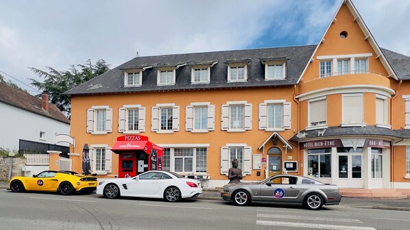A building with a restaurant, bar, and hotel. There are three cars parked in front. - Group gîte, jacuzzi-sauna-heated pool 43prs (Vivoin)