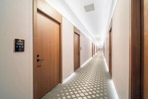 A hotel hallway with wooden doors, a check-in desk, and a patterned floor. - U-FREE Hotel (Jiading Jialuo Road) (Shanghai)