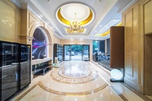 A hotel lobby with a chandelier, a circular floor design, a large glass door leading outside, and a television on the left. - U-FREE Hotel (Jiading Jialuo Road) (Shanghai)