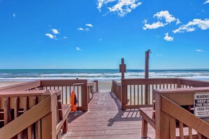 A wooden boardwalk leading to a beach with a lifeguard tower and a warning sign about a $500 fine for trespassing. - Beachfront Condo | Pool, Elevator, Park, Deck + Ocean & Sound Views (North Topsail Beach)