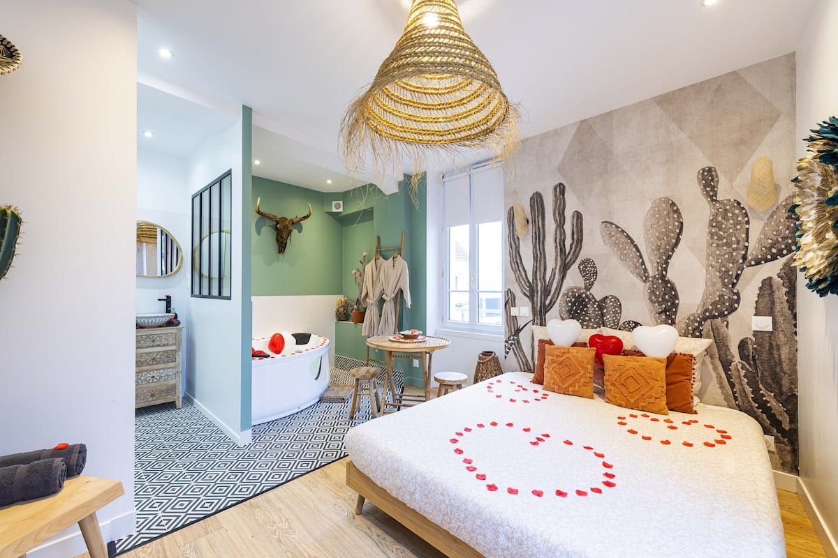 A bedroom with a bed, a bathroom, a dining area, and a living room.
