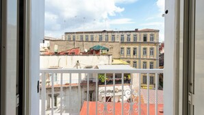 A view from a balcony with a railing, overlooking a street with buildings and a clear sky. - Vico Santa Maria del Pozzo 9 (Naples)
