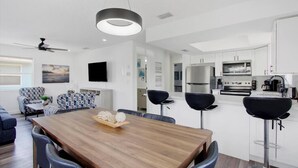 A modern kitchen with white cabinets, a built-in oven, and a stainless steel refrigerator. - Indian Rocks Beach Gem - Renovated 2BR Beach House (Indian Rocks Beach)