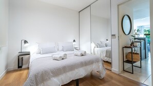 A bedroom with a bed, bedside tables, a mirror, and a view of the outdoors. - Ayacucho Apartment | Style & Comfort in Recoleta (Ciudad Autónoma de Buenos Aires)