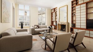 Una sala de estar con sofá, sillones, una mesa de centro y chimenea.