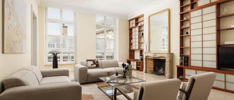 Un salon comprenant un canapé, des fauteuils, une table basse et une cheminée.