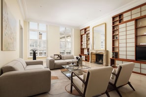 A living room with a sofa, chairs, a coffee table, and a fireplace.