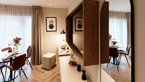 Ein modernes Hotelzimmer mit Essbereich, einem großen Spiegel und Kunstwerken an den Wänden.