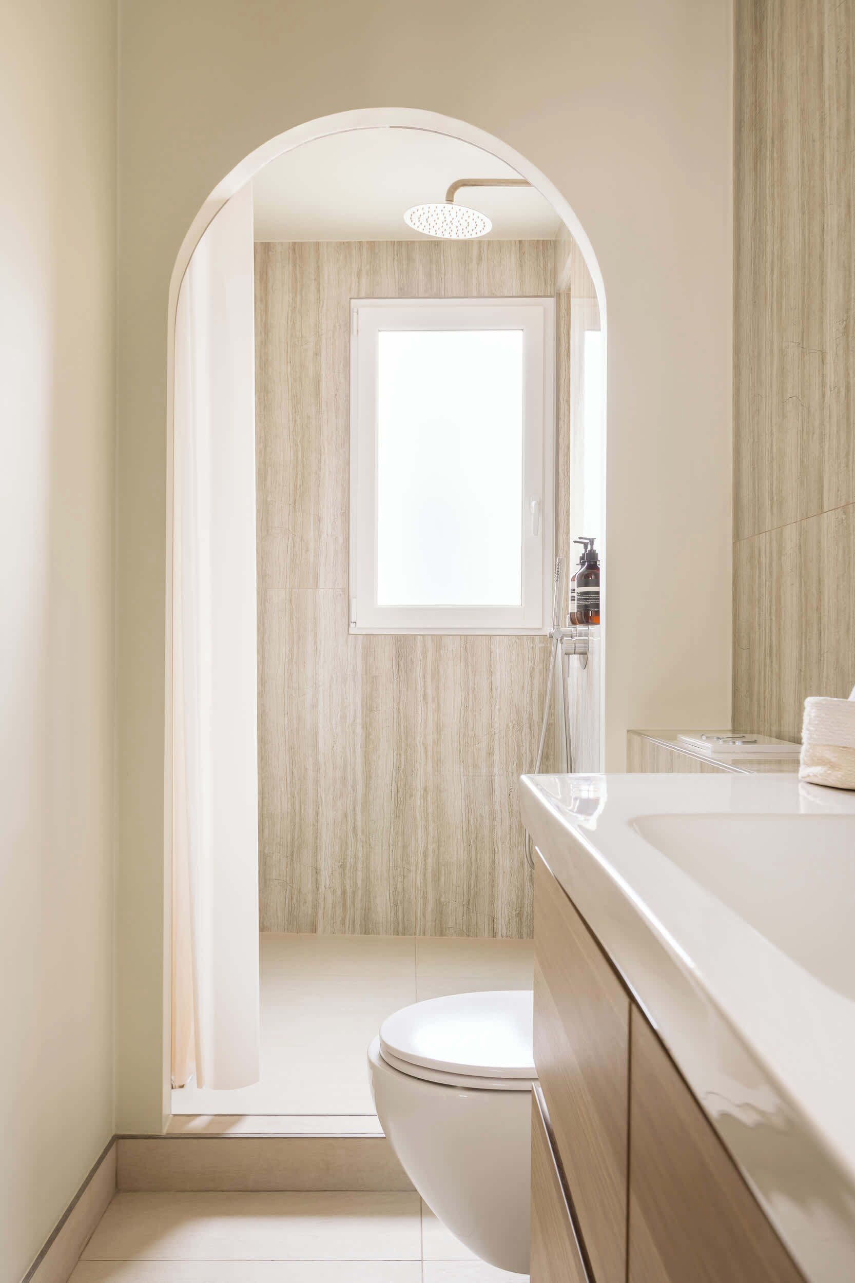 A modern bathroom with a shower, toilet, and vanity.