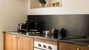 Una cocina con armarios de madera, una estufa, un tostador y una repisa con adornos.