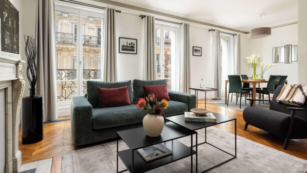 A living room with a sofa, coffee table, and dining area.
