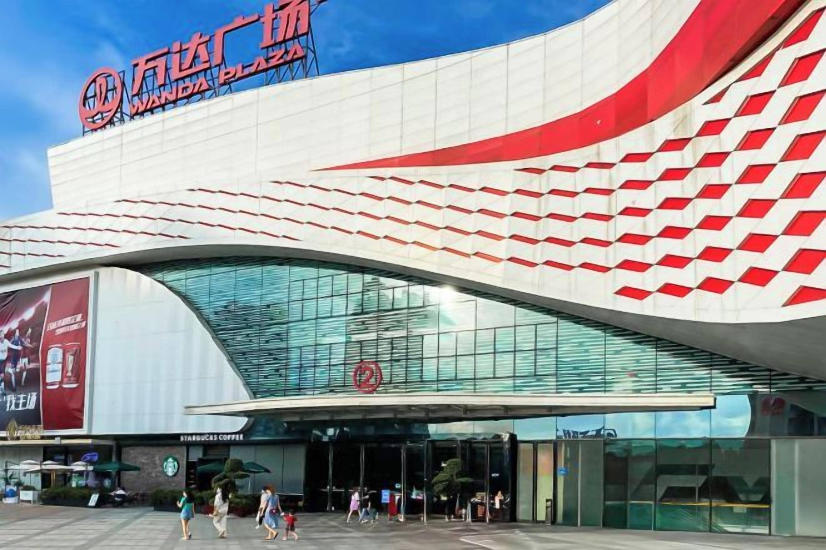 A modern building with a curved facade and a prominent red and white design.