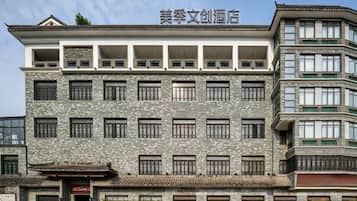 A multi-story hotel with a traditional architectural style, featuring a prominent entrance with a red sign.