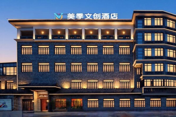 A multi-story hotel building with a modern architectural design, featuring a prominent entrance and multiple balconies.