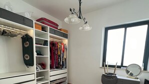 A room with a wardrobe, shelves, a vanity with a mirror, and a window. - Villa Lucia Sea View Holiday Home (Marina di Palma)