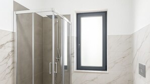 A modern bathroom with a glass-enclosed shower, a toilet, and a sink. - Villa Lucia Sea View Holiday Home (Marina di Palma)