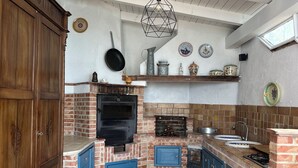 A kitchen with a brick oven, blue cabinets, and a wooden cabinet. - Villa Lucia Sea View Holiday Home (Marina di Palma)