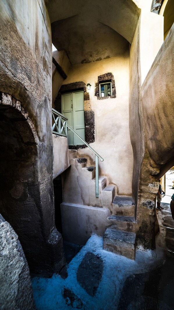 A narrow stone staircase leading to a door with a small window above it.