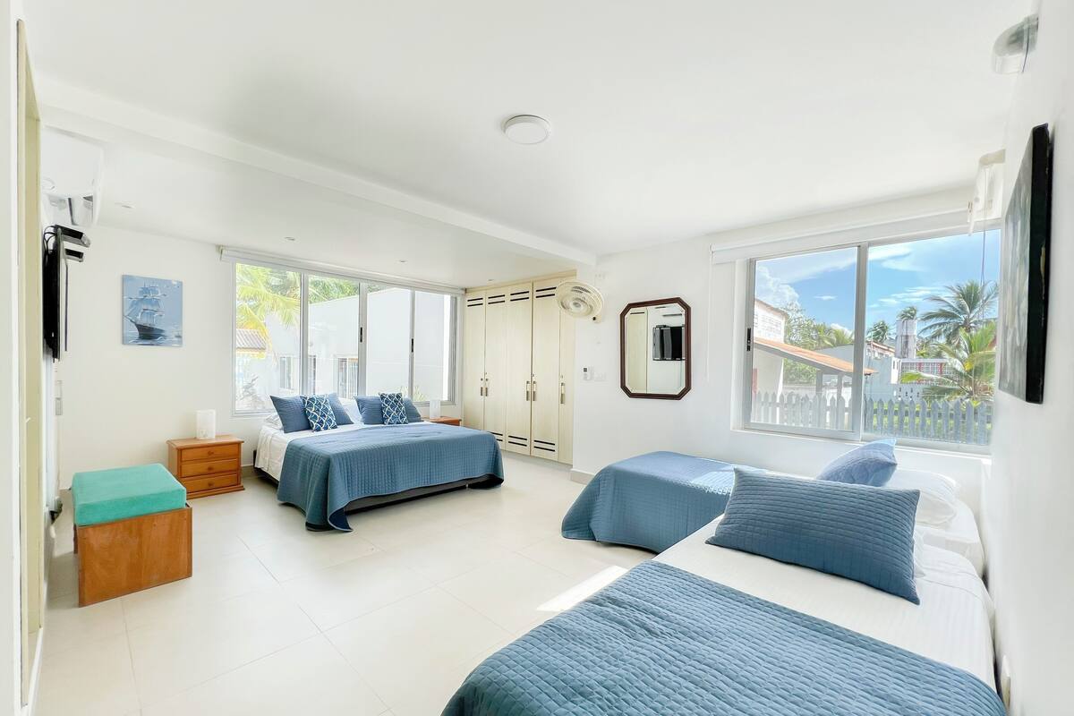Un dormitorio con dos camas, un ventanal y vistas al exterior.