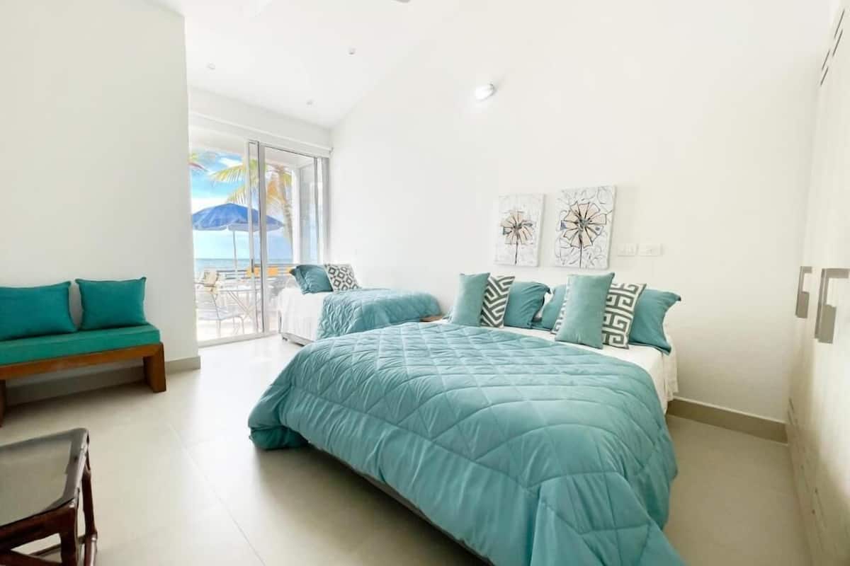 Un dormitorio con una cama grande, un sofá y vistas al exterior.