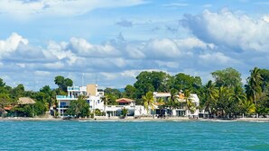 A coastal view with buildings, palm trees, and a beach. - Quinta del Mar El Francés (Tolu)