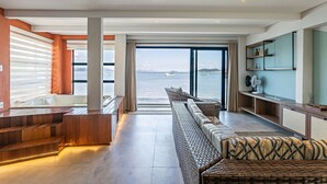 Un espace de vie moderne avec vue sur la mer, un escalier en bois et un canapé.