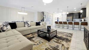 A modern living room with a sectional sofa, a coffee table, and a patterned rug.