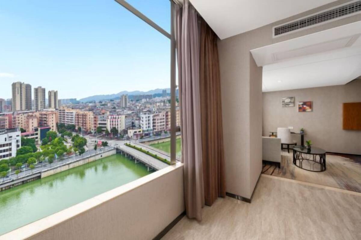 Un apartamento alto con vistas a la ciudad, una mesita y una silla.