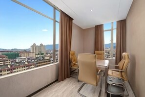 A high-rise room with a city view, a dining table, two chairs, and a small side table. - Bai Li Holiday Hotel (Enping Aofeng Square) (Enping)