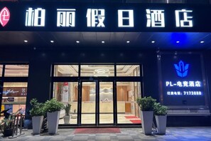 A hotel entrance with a clear sign, potted plants, and a visible reception area. - Bai Li Holiday Hotel (Enping Aofeng Square) (Enping)