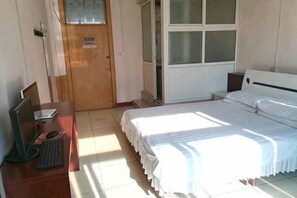 A bedroom with a bed, a desk with a computer, a wardrobe, and a window. - Liaocheng Chiping Jinda Business Hotel (Guan County)