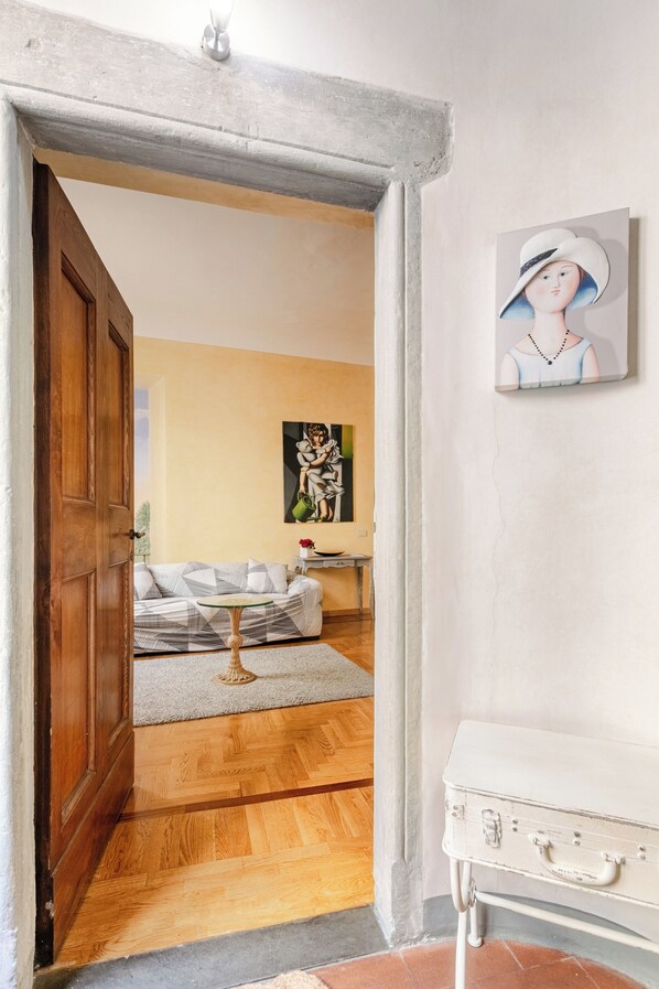 A room with a wooden door, a white cabinet, and a painting on the wall.