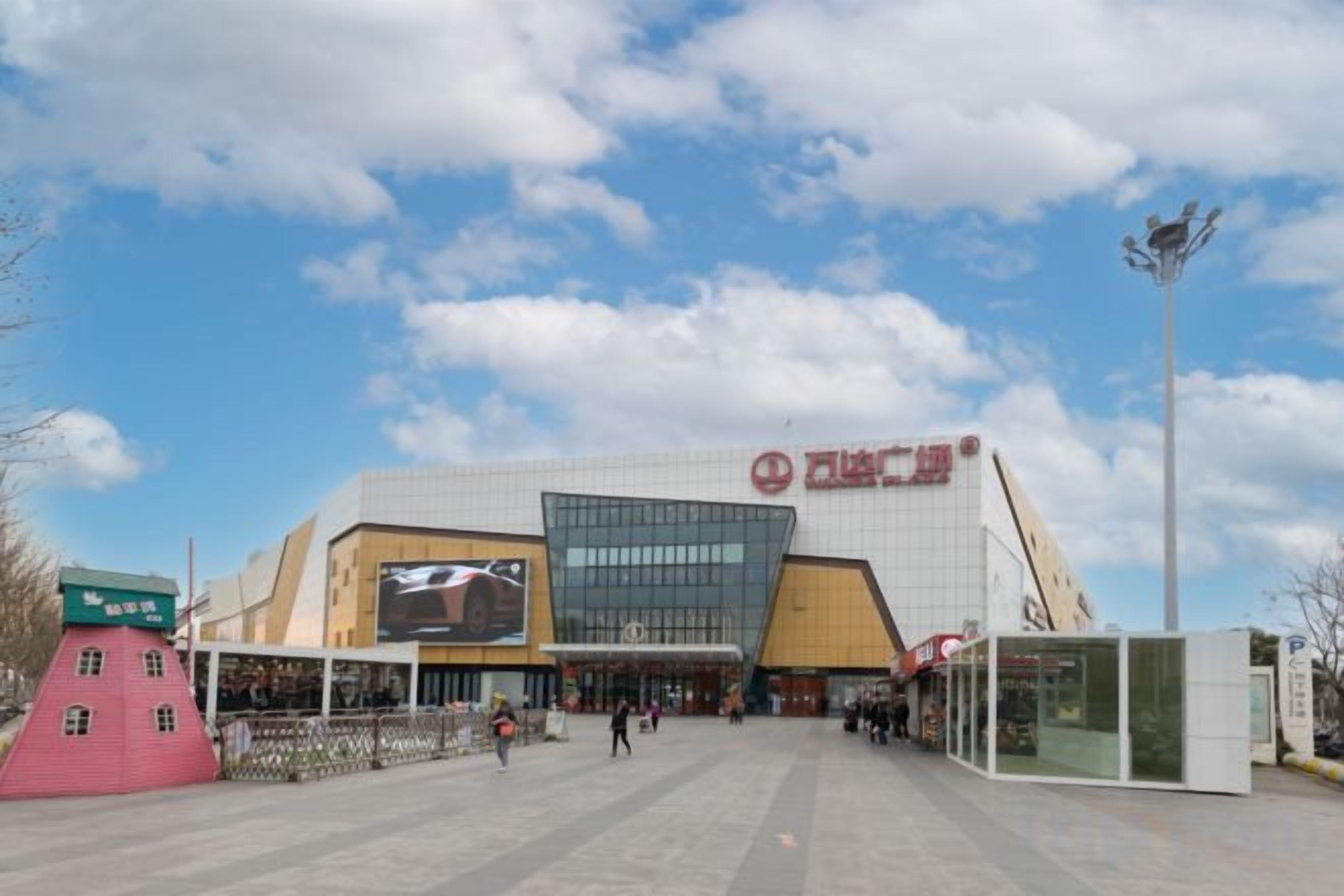 A large, modern building with a prominent entrance and a large digital display.