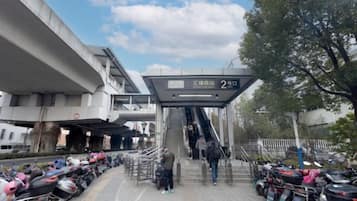 Uma passarela para pedestres com escadas que levam a uma entrada, cercada por motocicletas e bicicletas estacionadas.