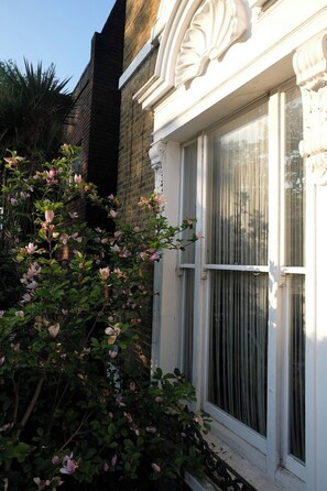 A building with a white window and a brick wall. - London 2 bed | Iconic Abbey Road | Zone 2 (London)