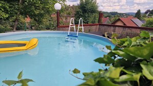 A swimming pool with a ladder and a yellow inflatable float. - Cozy and quiet vacation apartment with private garden in beautiful Thuringia (Schmalkalden)